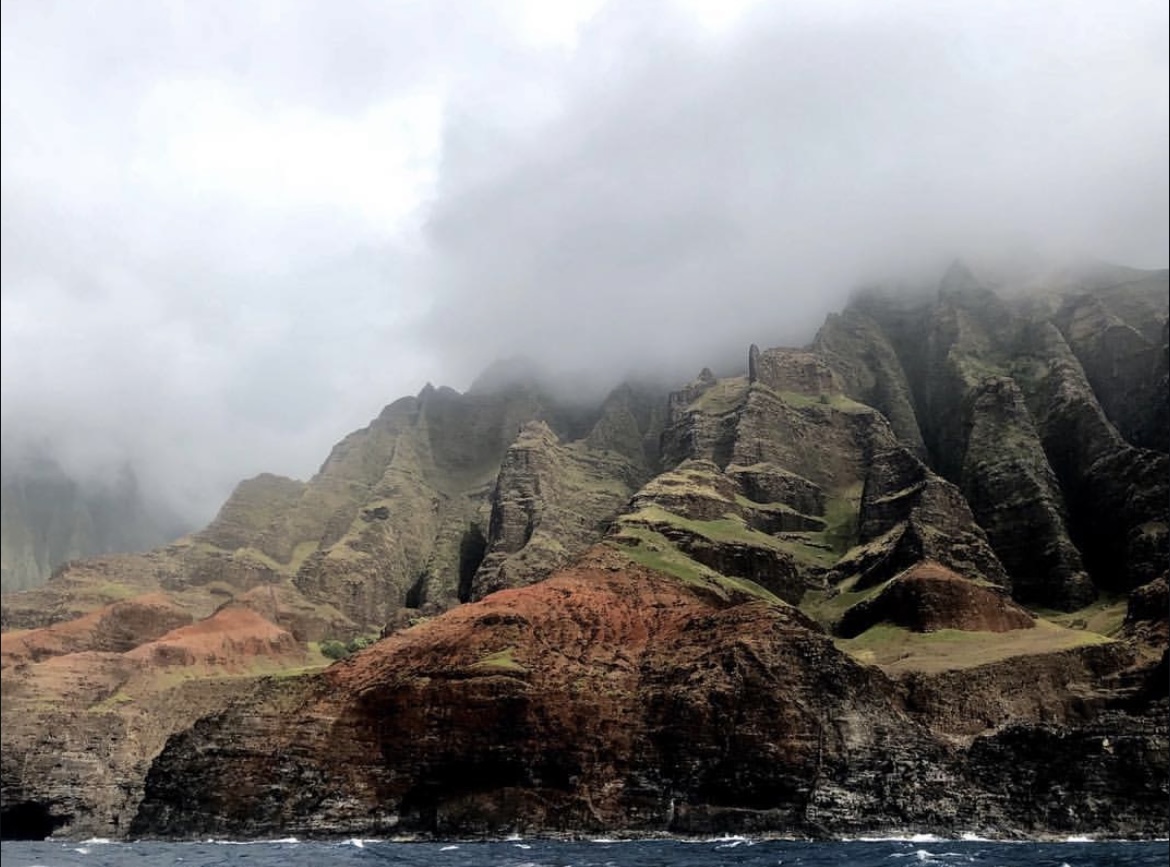 Emerald-hued cliffs along the Pacific Ocean. Overcast and foggy sky.
