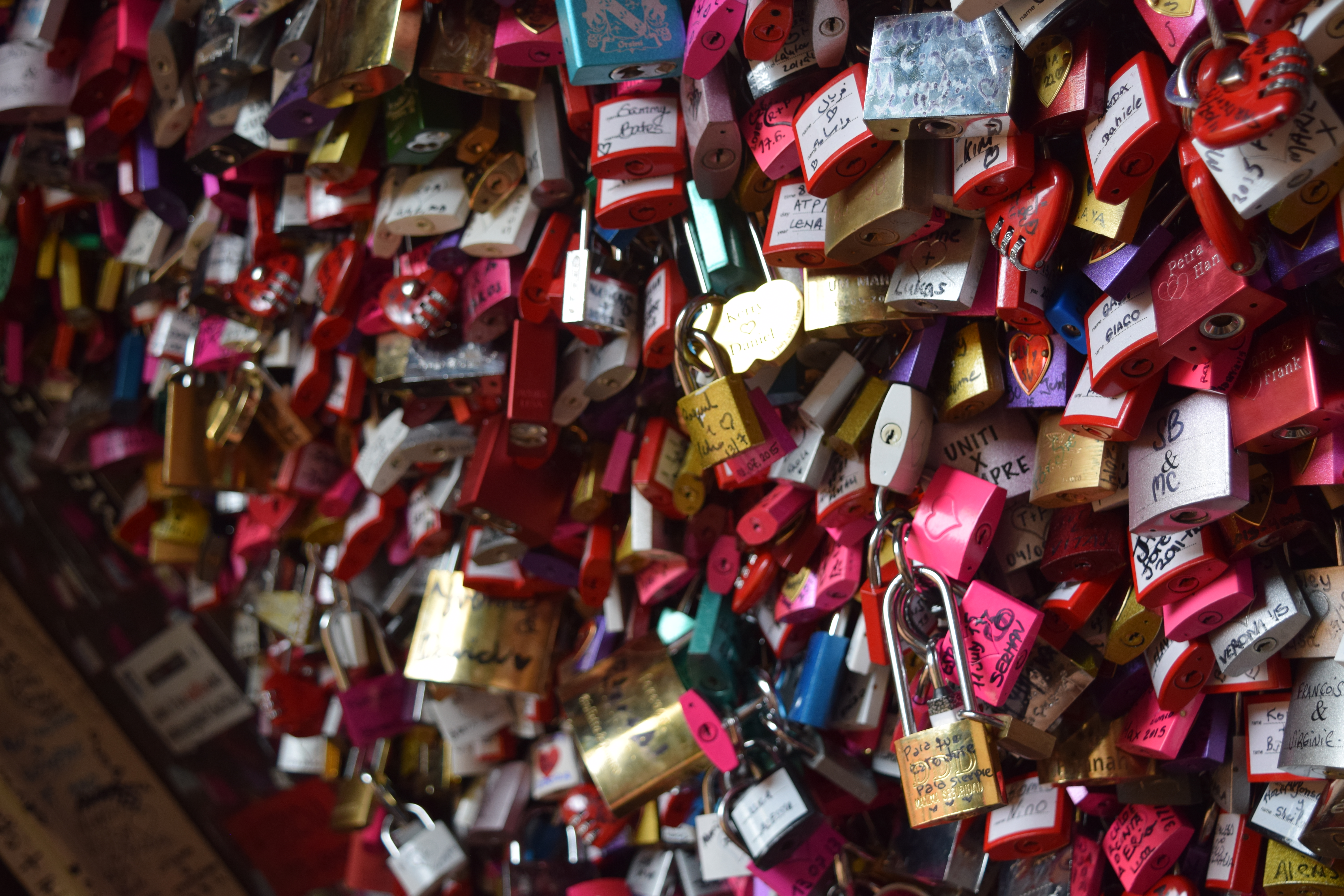 Tons of locks on a gate with names of loved ones on them.