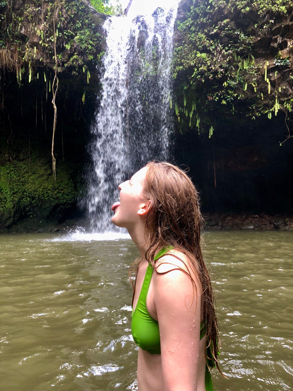 Girl under Twin Falls on the Road to Hana in Maui, Hawaii